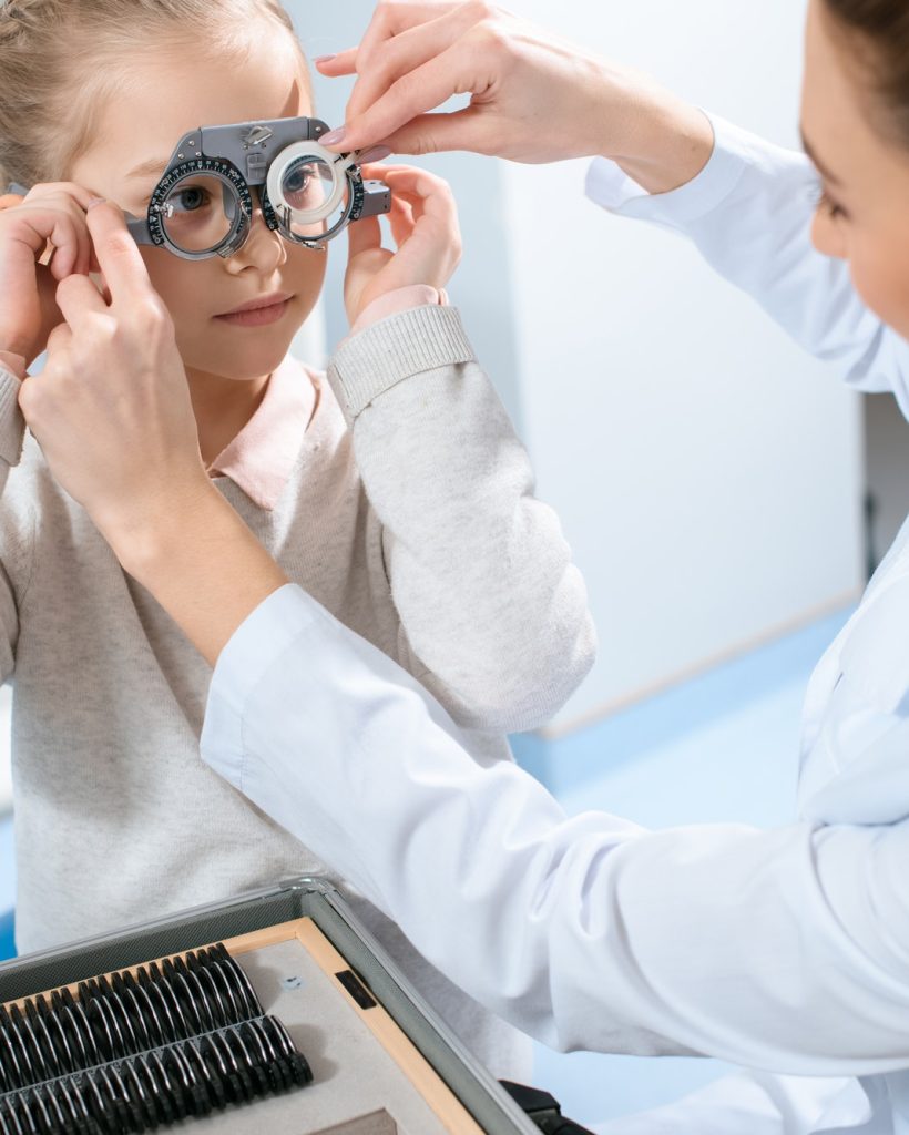 female-ophthalmologist-examining-kid-eyes-with-trial-frame-and-lenses.jpg